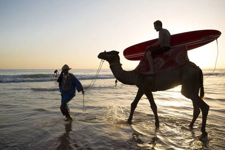 Car rental Agadir airport vehicle parked near the beautiful Taghazout beach, providing easy access for surfers and travelers.
